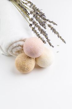 Homemade salt bath bombs with dry lavender flowers and white towel. Natural cosmetics