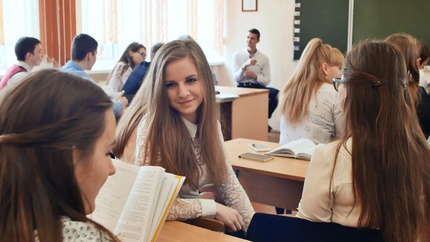 Students communicate between lessons sitting at a desk. Russian school