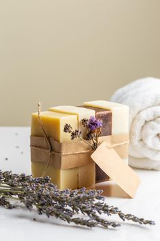 Pack of four different handmade natural soap bars with dry lavender flowers and empty label. Vertical composition with copy space