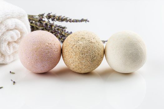 Homemade salt bath bombs with dry lavender flowers and white towel. Natural cosmetics