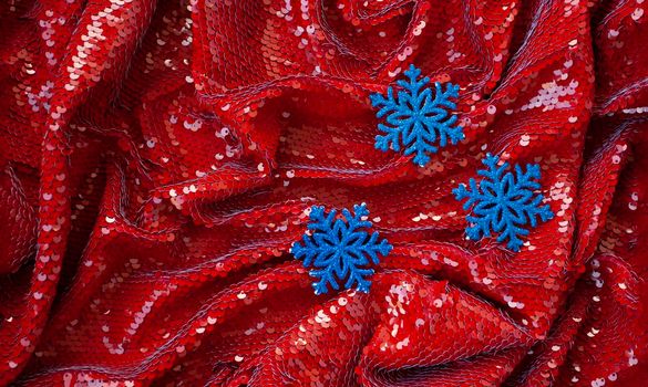 Red festive background with glitter and three blue decorations for Christmas tree for lettering and greeting card