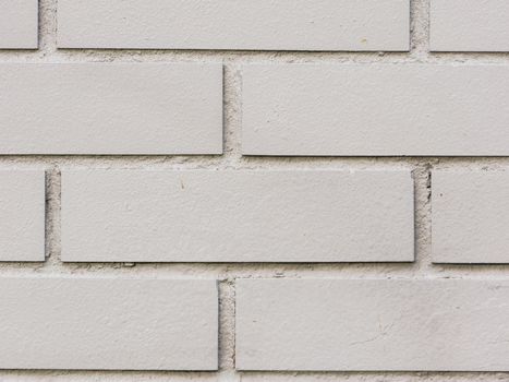 Painted brick wall and weathered sidewalk.