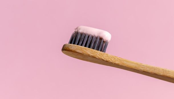 Ecological toothbrush made from natural bamboo. Sustainable lifestyle concept, zero waste. Copy space. Pink background