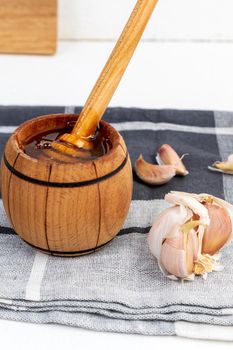 Fermented garlic cloves honey, a rich source of probiotics, white background. Vertical photo