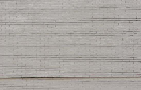 Close-up shot of a grey brick wall. Abandoned wall of a brick building.