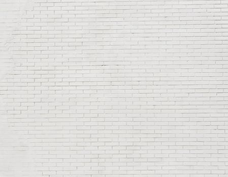 Painted brick wall and weathered sidewalk .