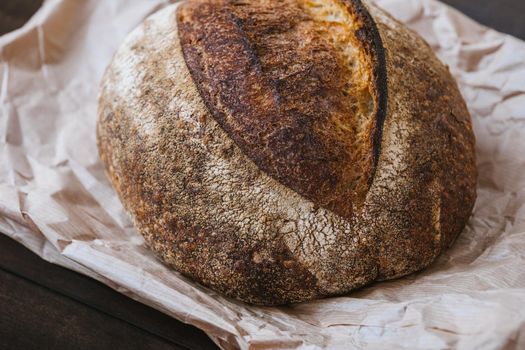 Close-up hot rye circle bread with crispy crust on a craft package.