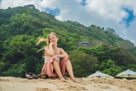Young woman traveler on amazing Melasti Beach with turquoise water, Bali Island Indonesia.