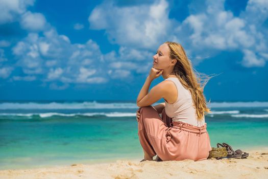 Young woman traveler on amazing Melasti Beach with turquoise water, Bali Island Indonesia.