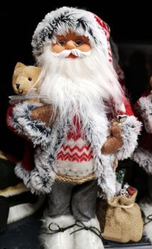 Santa Claus as toy with glasses and holiday costume. Traditional Christmas toy fair.
