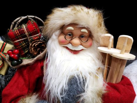 Santa Claus as toy in red suit costume with glasses. Traditional Christmas toy fair.