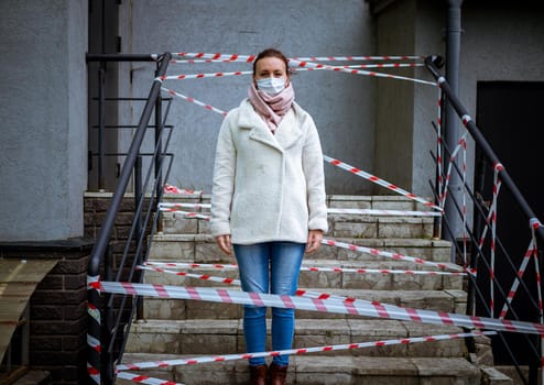 Photo of a girl in a mask. Standing on the street with danger warning tapes. isolated Covid-19 pandemic.