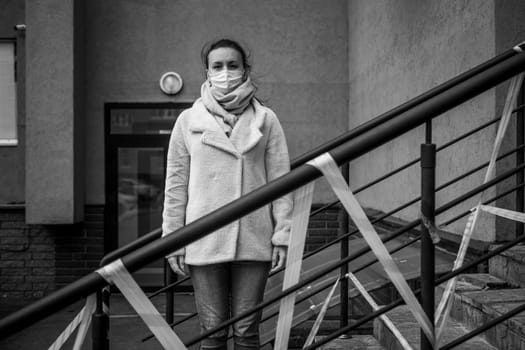 Photo of a girl in a mask. Standing on the street with danger warning tapes. isolated Covid-19 pandemic.