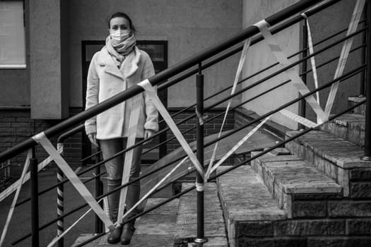 Photo of a girl in a mask. Standing on the street with danger warning tapes. isolated Covid-19 pandemic.