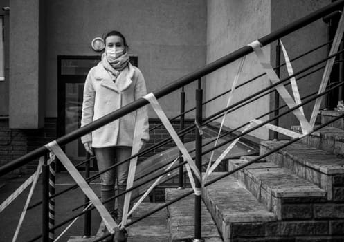 Photo of a girl in a mask. Standing on the street with danger warning tapes. isolated Covid-19 pandemic.