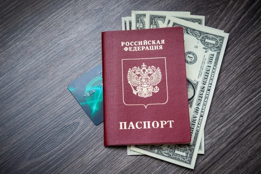 A foreign passport and dollars on a wooden background. Photos of documents and banknotes.