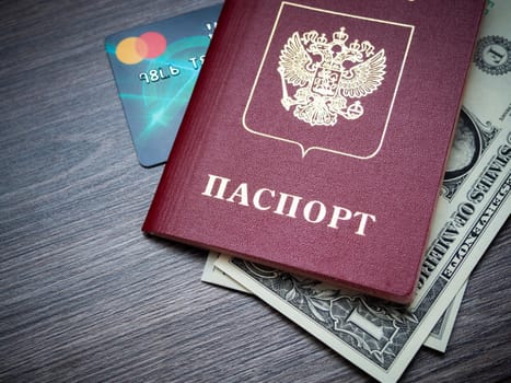 A foreign passport and dollars on a wooden background. Photos of documents and banknotes.