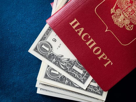 A foreign passport and dollars on a blue background. Photos of documents and banknotes.