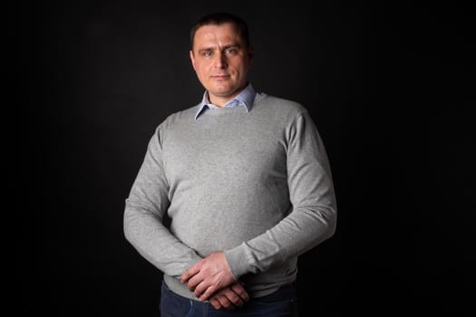 handsome businessman in a suit looks at the camera. isolated on a black background