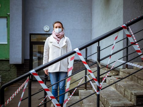 Photo of a girl in a mask. Standing on the street with danger warning tapes. isolated Covid-19 pandemic.