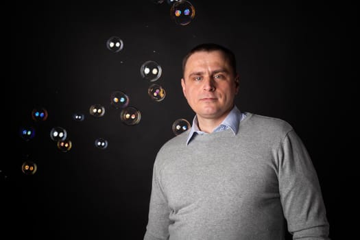 handsome businessman in a suit looks at the camera. isolated on a black background