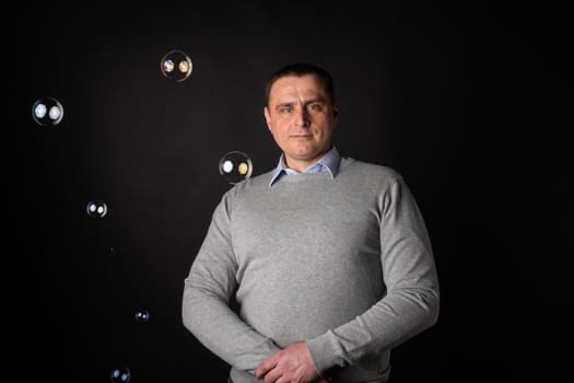 handsome businessman in a suit looks at the camera. isolated on a black background