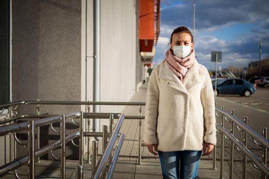 A picture of a girl in a mask. On the street. isolated Covid-19 pandemic.