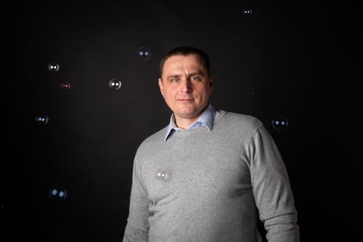 handsome businessman in a suit looks at the camera. isolated on a black background