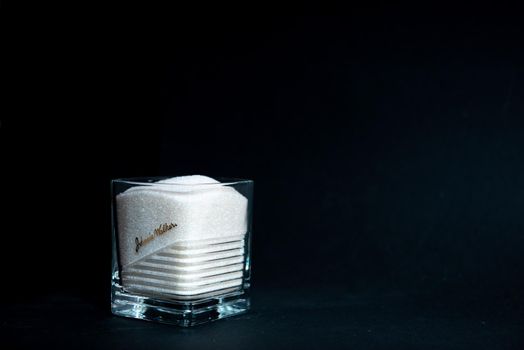 sugar in a transparent glass with a corrugated face on a black background