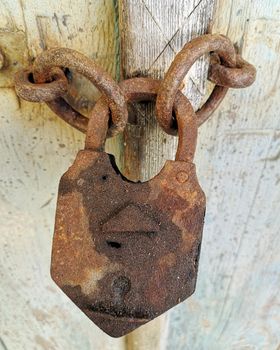 Old rusty padlock on wooden background
