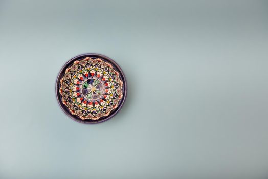 Ethnic Uzbek ceramic tableware on the gray background. Decorative ceramic cup with traditional uzbekistan ornament.