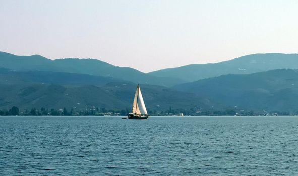 A lonely sailboat sailing on the sea 