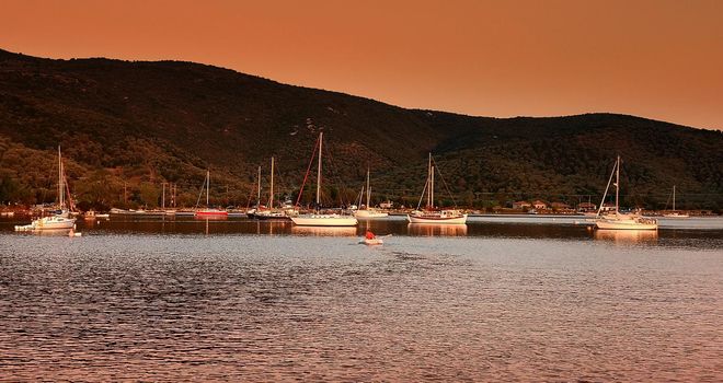 Sailboats anchored in a beautilful bay at sunset