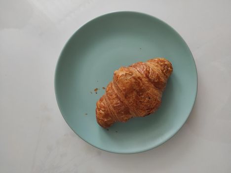 croissant on a salad-colored bowl.