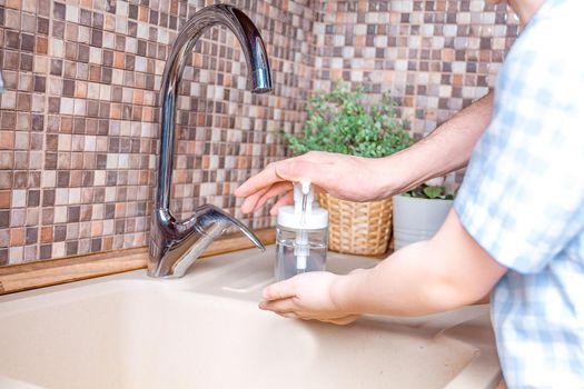 Happy little boy and his father washing hands together with a soap in bathroom