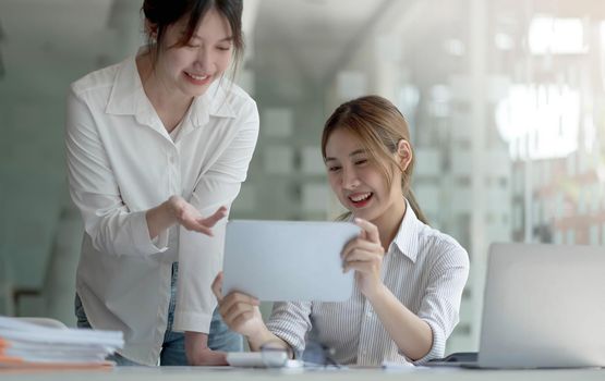 Young Asian businesswoman work together to analysis from work at the office..