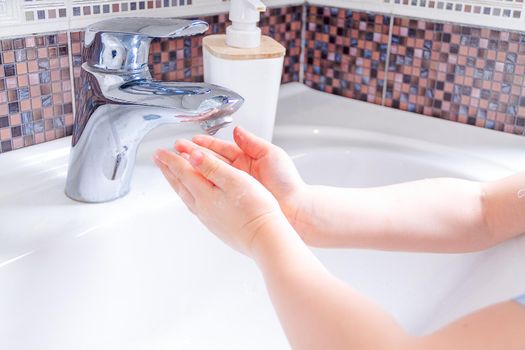 Close up hands of children Washing hands with soap under the faucet with water. clean and Hygiene concept