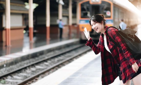 Young traveler woman looking for friend planning trip at train station. Summer and travel lifestyle concept.