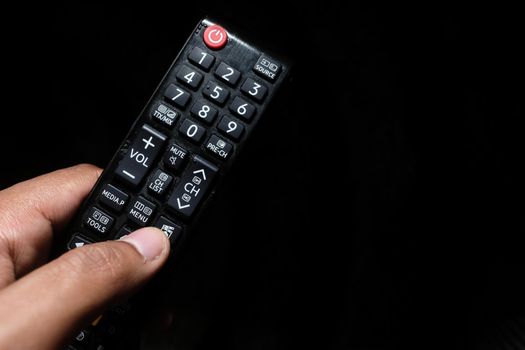 close up of man hand holding tv remote