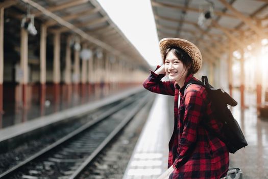 Young traveler woman looking for friend planning trip at train station. Summer and travel lifestyle concept.