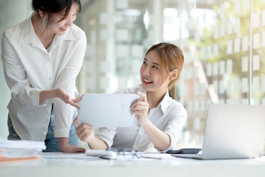 Young Asian businesswoman work together to analysis from work at the office..