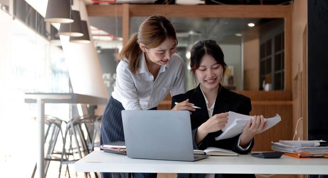 Two young asia business woman working together in office space.