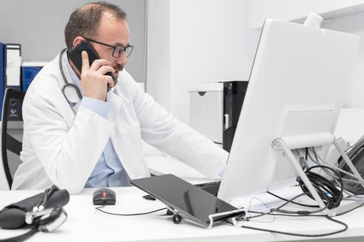 Doctor in office talking on phone. High quality photography.