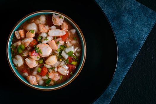Red shrimp ceviche. Mexican food. Low key lighting on black and blue background