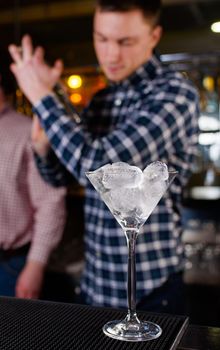 Expert barman is making cocktail at night club, Barman holds a cocktail in his hand. No face. Selective focus