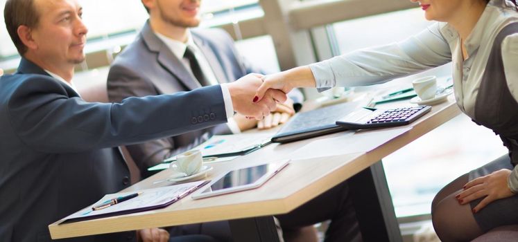 Business handshake. Handshake of two business men closing a deal at the office