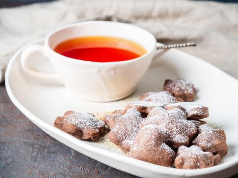 Winter holiday composition, side view, copy space, gray blue background. Tea, flax cookies with cinnamon.