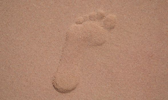 Top view of footprints in sand at beach, lonely trace on sandy surface on coast. Summer sea vacation and leisure at sea concept