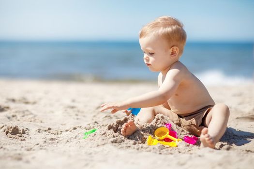 A boy plays in the sand on the beach near the sea. Great vacation by the Baltic Sea.