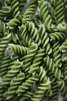 Raw green fusilli pasta, natural based on spinach and spirulina. Delicious and healthy food. Close-up